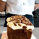 Bizcocho con crema y nueces pecanas, en las manos de una persona del equipo.